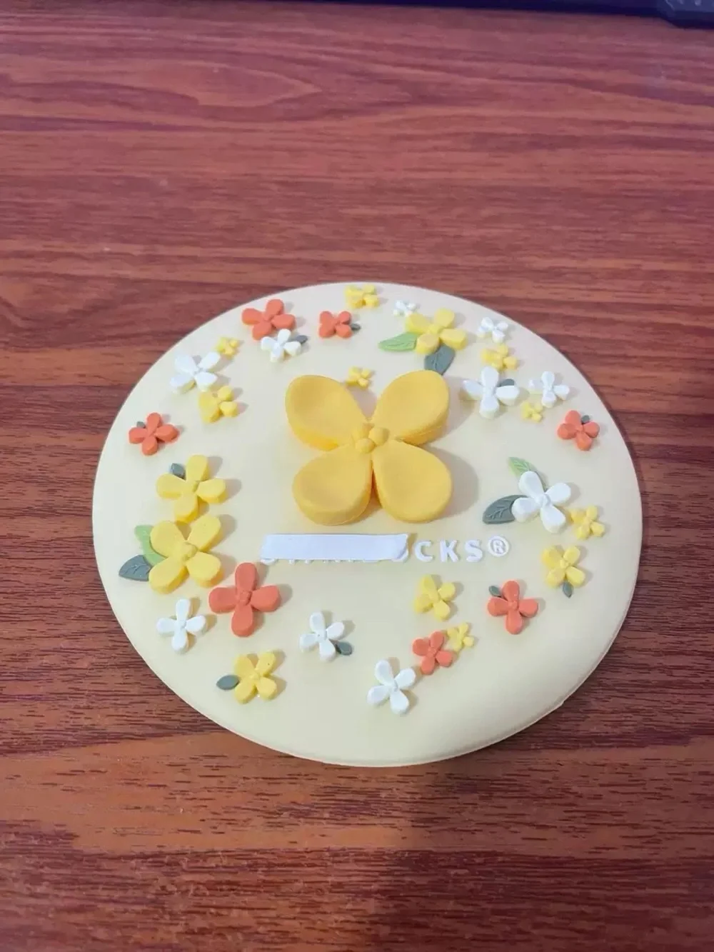 Starbucks Cream Silicone Trivet with Yellow and Orange Floral Accents mug lid